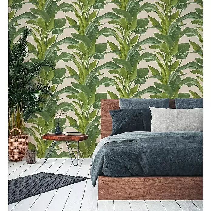 A.S. Création Metropolitan Stories II Vliestapete Blätter - Grün, Floral, 10,05 x 0,53 m - Tropische Tapete mit großen grünen Bananenblättern auf hellem Hintergrund, bedeckt eine Schlafzimmerwand hinter einem Holzbett.