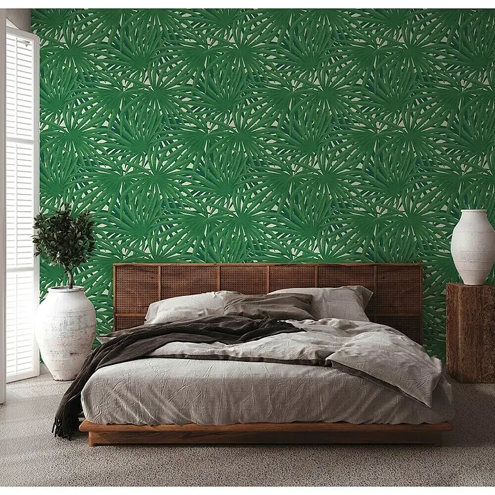 A.S. Création Metropolitan Stories II Vliestapete Palme - Grün, Floral, 10,05 x 0,53 m - Ein Schlafzimmer mit einem Holzbett, grauer Bettwäsche und einer grünen Blättertapete für ein tropisches Ambiente.