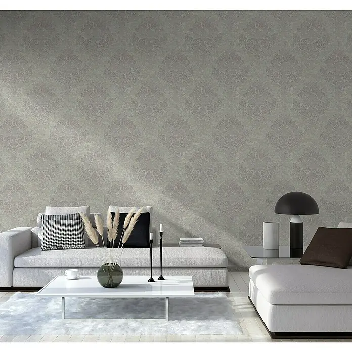 A.S. Création Metropolitan Stories II Vliestapete Damask - Grau, Ornament, 10,05 x 0,53 m - Wohnzimmer mit stilvollem grauen Sofa, Zierkissen und modernem Couchtisch auf einem weichen, weißen Teppich. Elegante Inneneinrichtung mit Tapetenmuster.