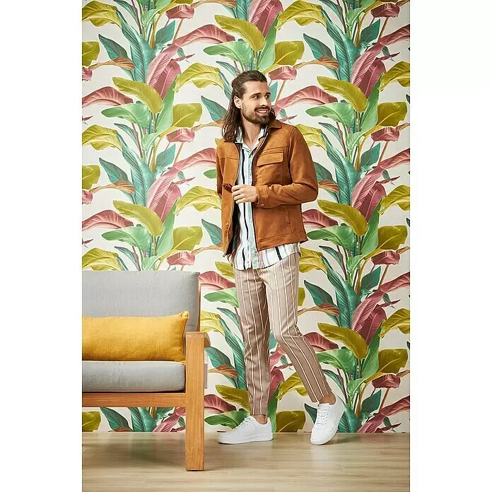 A.S. Création Metropolitan Stories II Vliestapete Blätter - Bunt, Floral, 10,05 x 0,53 m - Mann in brauner Jacke, gestreiftem Hemd und gestreifter Hose, kombiniert mit weißen Sneakern.