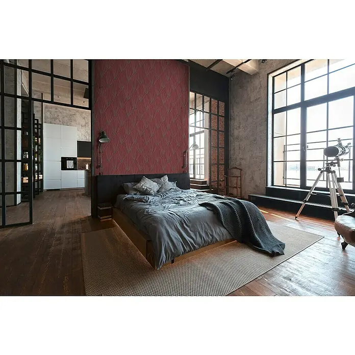 A.S. Création Metropolitan Stories II Vliestapete Grafik I - Rot, Grafisch, 10,05 x 0,53 m - Schlafzimmer mit einem Kingsize-Bett auf einem Teppich in einem Zimmer im Industriestil mit großen Fenstern. Die Bettwäsche ist grau.