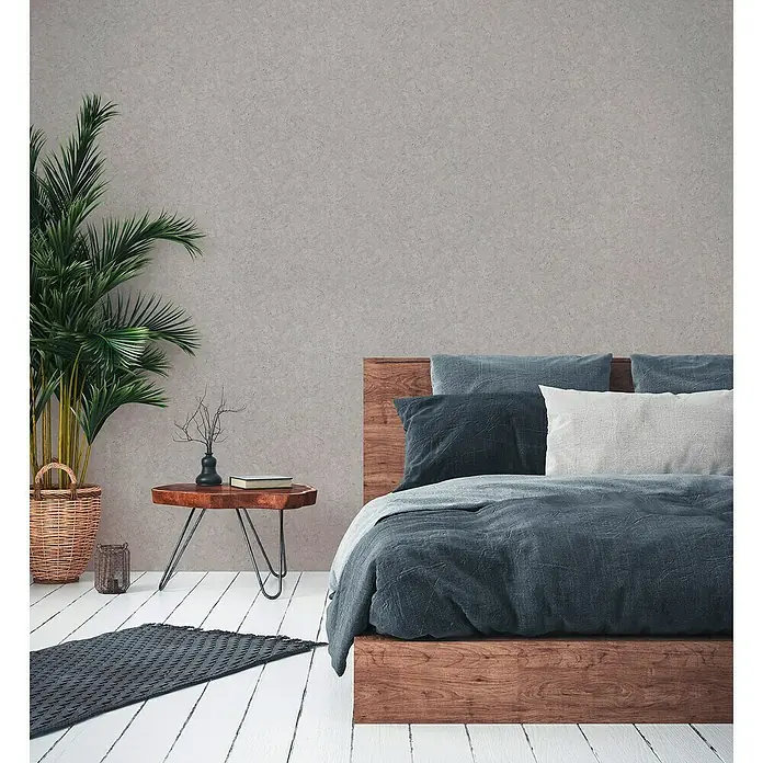 A.S. Création Metropolitan Stories II Vliestapete - Grau, Uni, 10,05 x 0,53 m, Matt - Schlafzimmer mit einem Holzbett mit blauer Bettwäsche, einem Holztisch und einer Topfpflanze.
