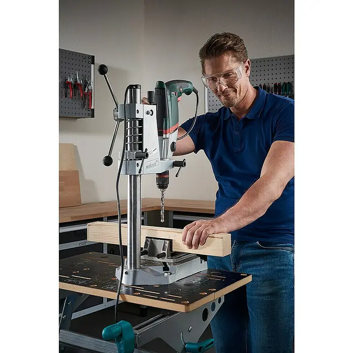 Wolfcraft Holzbohrer HSS Professional - 1 Stk., Durchmesser Bohrer: 12 mm - Ein Mann bedient eine Wolfcraft Bohrmaschine mit Ständer, trägt Schutzbrille und ein blaues Hemd.