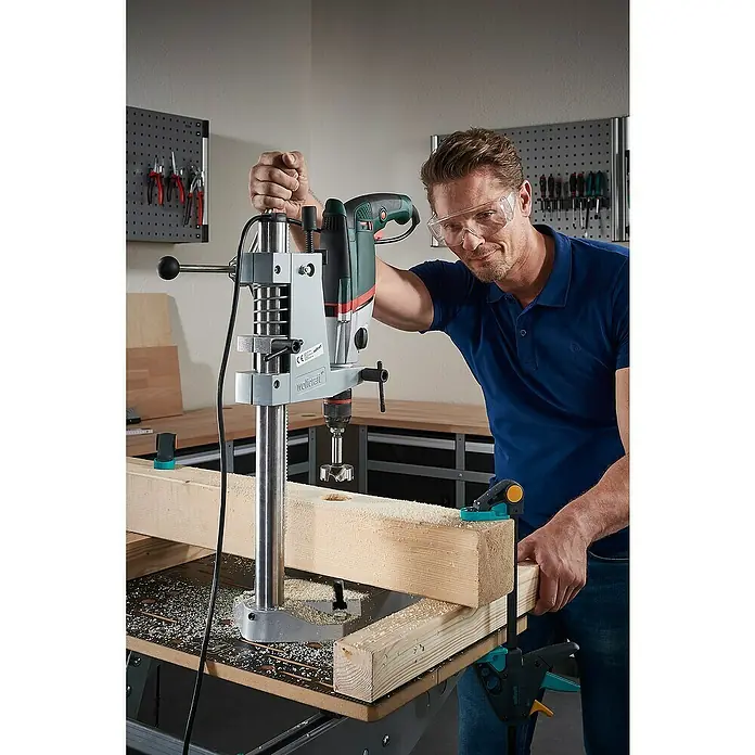 Wolfcraft Forstnerbohrer - Durchmesser Bohrer: 40 mm - Ein Mann benutzt eine Wolfcraft Bohrmaschine, um ein Loch in ein Holzbrett zu bohren, und trägt dabei eine Schutzbrille für Sicherheit.