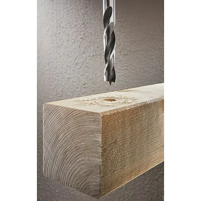 Wolfcraft Holzbohrer - Durchmesser Bohrer: 12 mm, Länge: 151 mm, 1 Stk. - Nahaufnahme eines Holzbohrers beim Bohren eines Lochs in ein Holzbrett, wobei die Details der Holzmaserung und des Bohrers hervorgehoben werden.