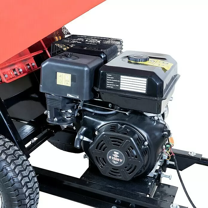 Güde Benzin-Häcksler GH 11.7-100 - Max. Aststärke: 10 cm, 8,6 kW, Hubraum: 420 cm³ - Nahaufnahme eines schwarzen Motors mit Beschriftung, montiert auf einem rot-schwarzen Gestell einer Outdoor-Maschine, mit grobem Reifen.