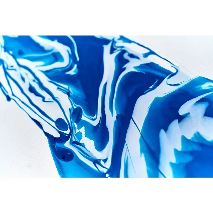 Liquitex Professional Gießmedium Matt - 473 ml, Transparent - Nahaufnahme von blau-weißer Acrylfarbe, die ein abstraktes Marmormuster erzeugt, ideal für künstlerische Projekte und kreative Designs.