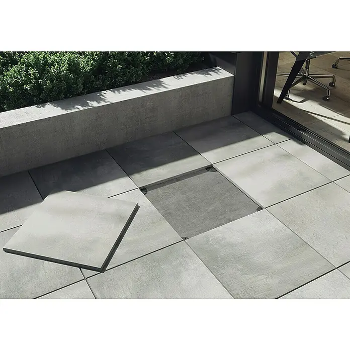 Cersanit Terrassenfliese Beton Grey Light - 59,3 x 59,3 x 2 cm, Grau, Matt - Hier sind Terrassenplatten aus Beton dargestellt, von denen eine lose ist, was die einfache Installation und Wartung betont.