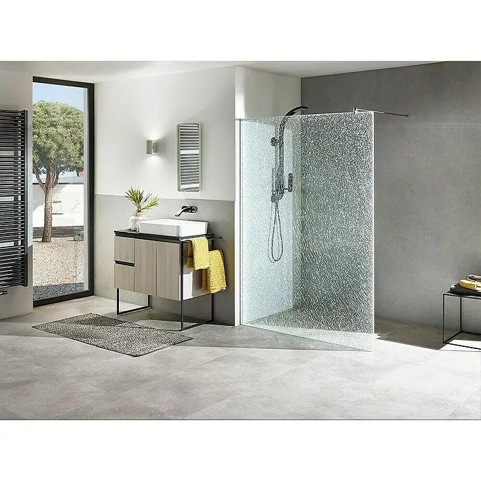 Camargue Duschwand Crash Glass S63 - B x H: 85 x 200 cm, Beschichtet - Modernes Badezimmer Interieur mit einem stilvollen Waschtisch mit Holzfronten, einer begehbaren Dusche mit Strukturglas und grauen Bodenfliesen.