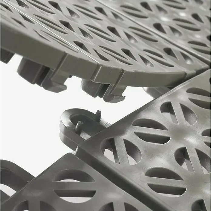 Klickfliese - Polyethylen, 55,5 x 55,5 x 1,1 cm, Mulitgrey, 1 Stk. - Nahaufnahme von Bodenfliesen aus grauem Kunststoff mit kreisförmigen Aussparungen, die für eine einfache Verlegung ineinandergreifen.