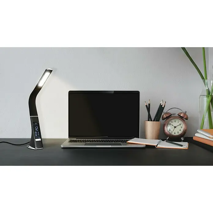 Tween Light LED-Tischleuchte Pelle - 3,2 W, Schwarz, Neutralweiß - Tischleuchte mit LED-Display auf einem Schreibtisch mit Laptop, Stiften und einem analogen Wecker. Die Leuchte strahlt helles Licht aus.