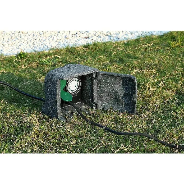 Voltomat Baustromverteiler mit Zeitschaltuhr Power Rock - Anzahl Steckdosen Schuko: 2 Stk., IP44 - Steckdosenverteiler im Außenbereich mit Zeitschaltuhr in einer schützenden Felsenbox auf Rasen.