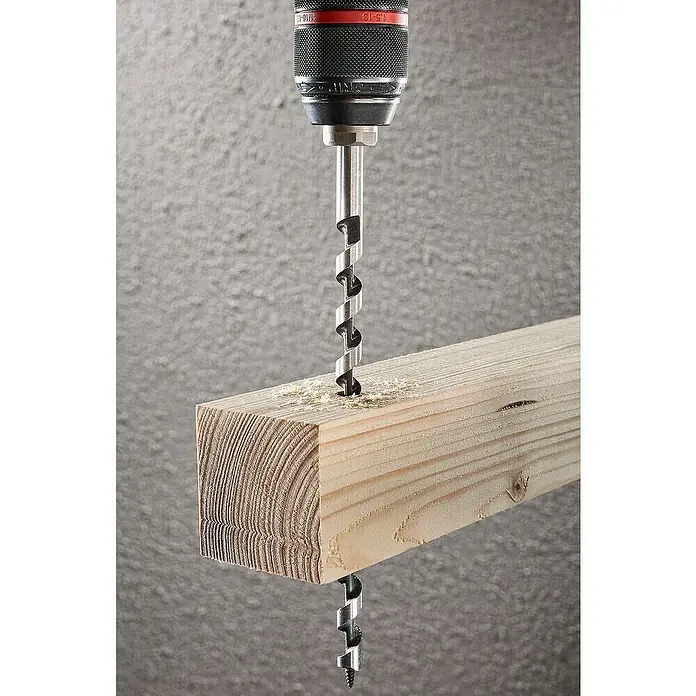 Wolfcraft Holzbohrer Standard - 1 Stk., Durchmesser Bohrer: 16 mm, Länge: 400 mm - Nahaufnahme einer Holzbohrmaschine, die ein Loch in ein Holzbrett bohrt, wodurch Sägemehl entsteht. Das Werkzeug ist sehr präzise.