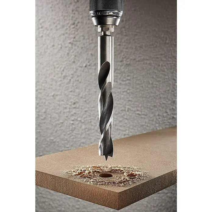 Wolfcraft Holzbohrer - Durchmesser Bohrer: 7 mm, Länge: 109 mm, 1 Stk. - Ein Bohrer bohrt ein Loch in ein Stück Holz und produziert Späne, die sich um das Loch herum ansammeln.