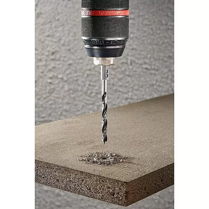 Wolfcraft Holzbohrer - 1 Stk., Durchmesser Bohrer: 6 mm, Sechskant - Schwarzes und rotes Bohrfutter mit Silberbohrer, der in eine hellbraune Holzplatte bohrt und Späne erzeugt.