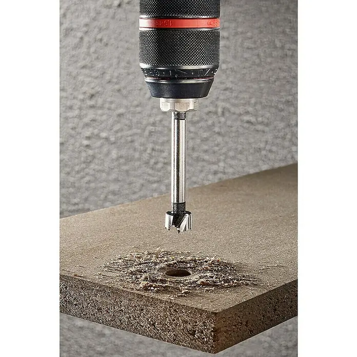 Wolfcraft Forstnerbohrer - Durchmesser Bohrer: 15 mm - Ein Forstnerbohrer bohrt ein Loch in ein Holzbrett und erzeugt dabei eine Menge Späne. Das Werkzeug ist präzise und effizient.