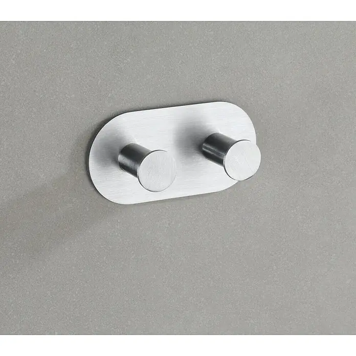 Wenko Handtuchhaken Cona Duo - Anzahl Haken: 2 Stk., Edelstahl, Matt - Nahaufnahme eines modernen, doppelten Edelstahl-Wandhakens, ideal für Badaccessoires und Handtücher, auf einer grauen Wand montiert.