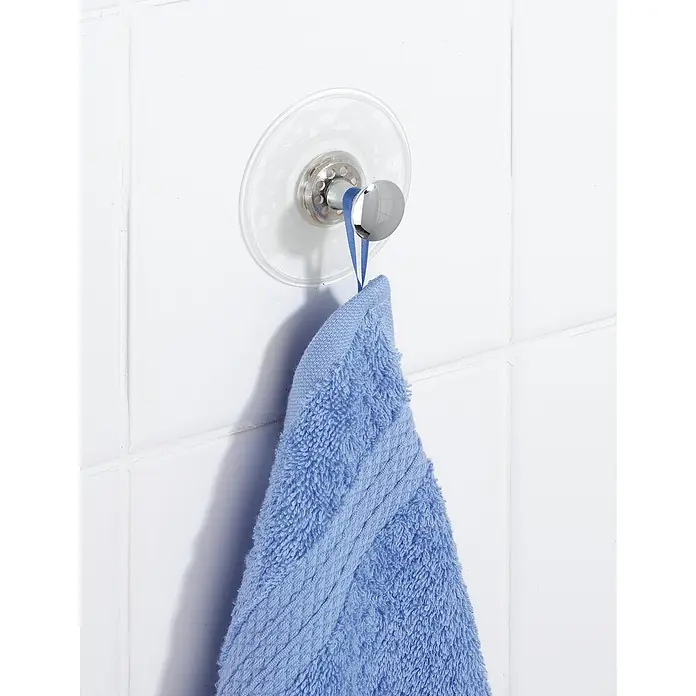 Wenko Saugnapf-Haken Arezzo - 1 Stk., Kunststoff, Transparent - Ein blaues Handtuch hängt an einem Saugnapf-Haken an einer weißen gefliesten Wand. Praktisch für Bad und Küche, um Handtücher aufzuhängen.