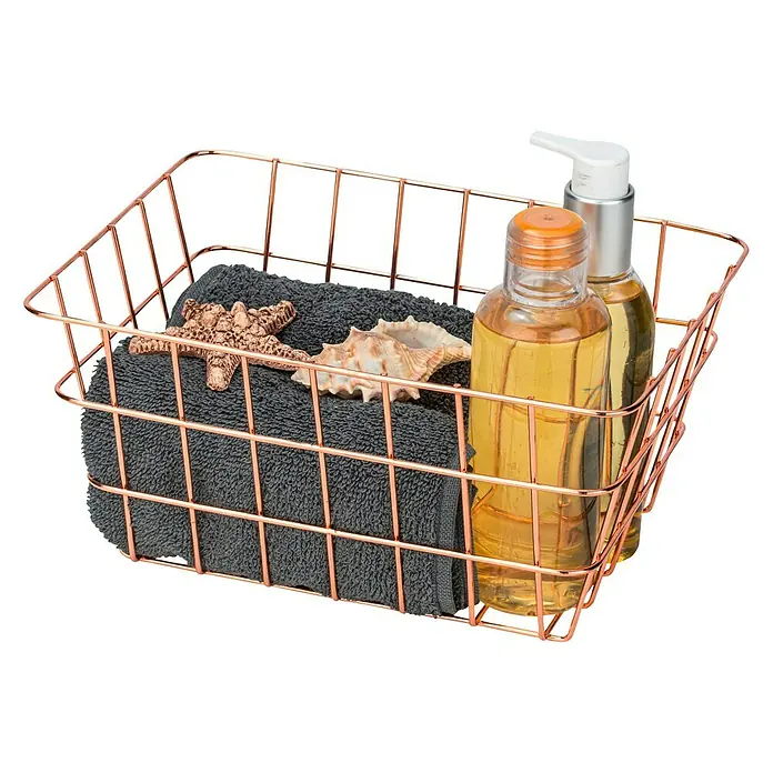 Wenko Bad-Aufbewahrungskorb Viana - L x B x H: 12 x 18 x 25 cm, Metall, Kupfer - Ein kupferfarbener Drahtkorb mit einer grauen Handtuchrolle, einem Seestern, einer Muschel und zwei Flaschen Pflegeprodukte.