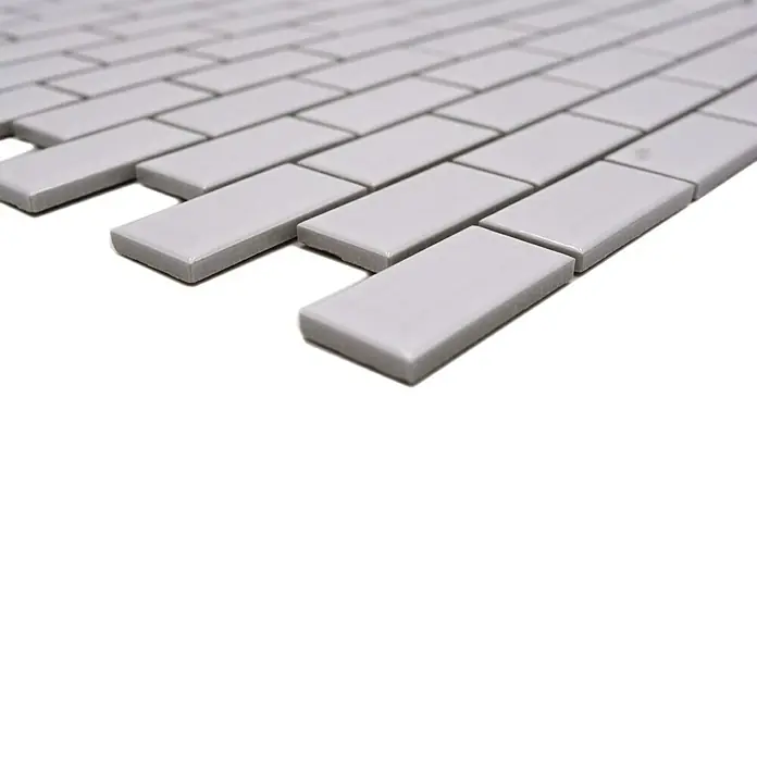 Mosaikfliese Brick Bond Diamond CBW 104 - 30 x 30 cm, Weiß, Glänzend - Nahaufnahme von grauen, rechteckigen Wandfliesen, die im Mauerverband angeordnet sind. Ideal für moderne Küchen- und Badgestaltungen.