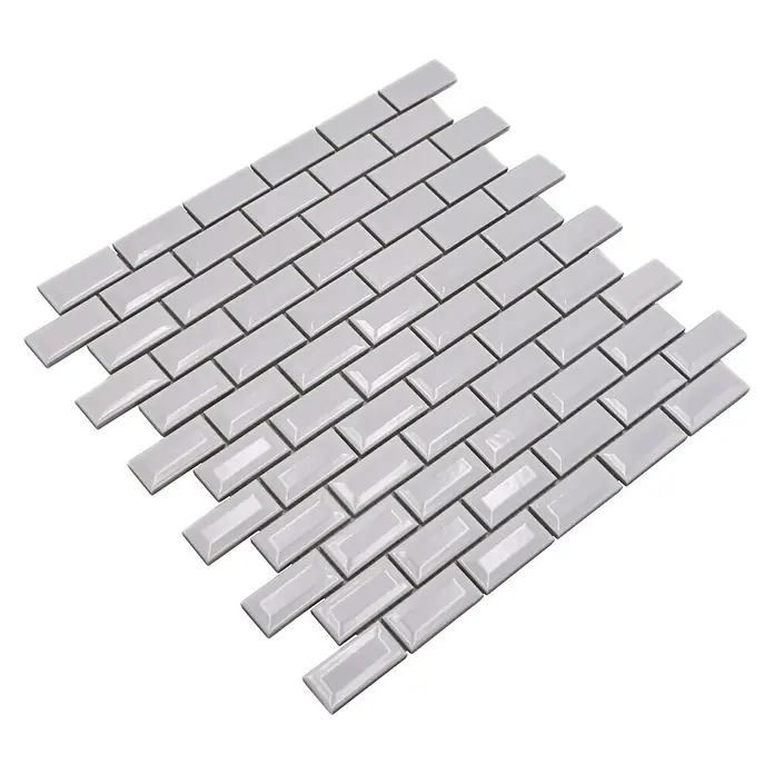 Mosaikfliese Brick Bond Diamond CBW 104 - 30 x 30 cm, Weiß, Glänzend - Das Bild zeigt eine Nahaufnahme von grauen, glänzenden Metrofliesen, die im Fischgrätmuster angeordnet sind. Sie sind rechteckig und leicht gewölbt.