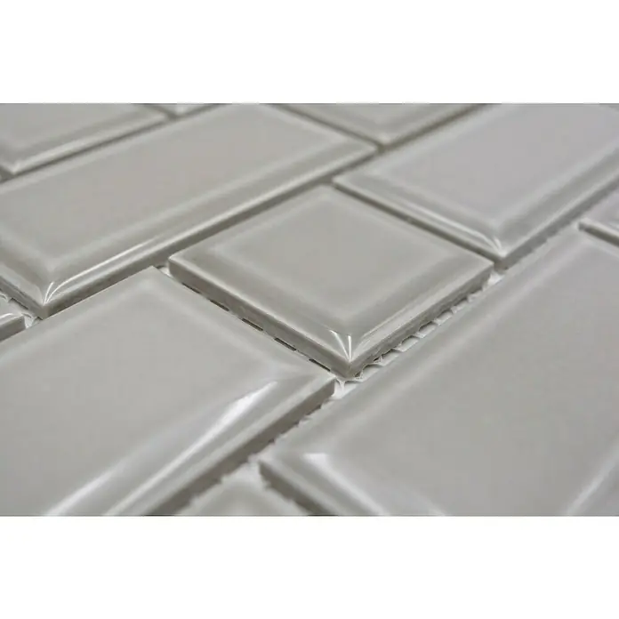 Mosaikfliese Metro Uni CG M04CM - 29,4 x 29,1 cm, Grau, Glänzend - Detailaufnahme von grauen glänzenden Keramikfliesen im Fischgrätmuster, ideal für moderne Wand- und Bodengestaltung.