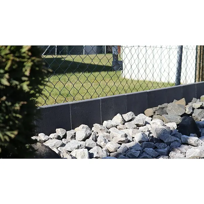 Christoph Mähstein Mähroboter L-Randstein - 24,5 x 29 x 15 cm, Anthrazit, Beton - Nahaufnahme einer stilvollen grauen Betonmauer mit dekorativen Felsbrocken, die einem Garten einen modernen Touch verleihen. Perfekt für die Gartengestaltung.