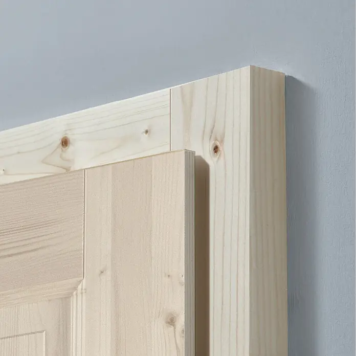 Kilsgaard Blockzarge 610 – 985 mm - 985 x 1.985 mm, DIN Anschlag: Links/Rechts, Fichte Natur - Nahaufnahme eines unlackierten Holzrahmens und einer Holztür, die die natürliche Maserung und Textur des Holzes hervorhebt.