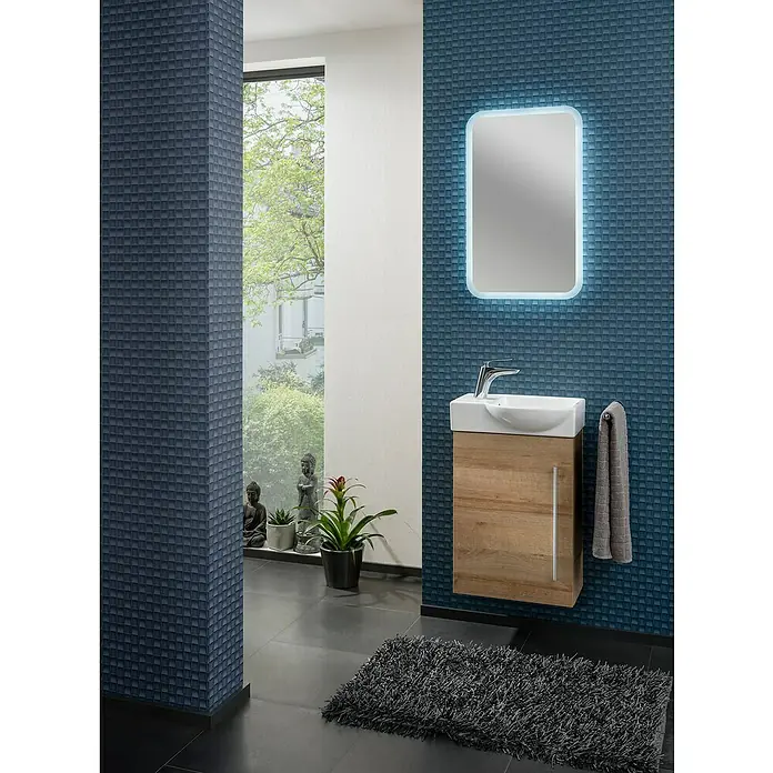 Camargue Stella K welcome Badmöbel-Set KW45BRE - Gesamtbreite Badmöbel: 45 cm, Berg Eiche, Matt, DIN Anschlag: Rechts - Modernes Badezimmer mit blau gemusterten Wänden, einem beleuchteten Spiegel und einem Waschbecken mit Holzunterschrank.