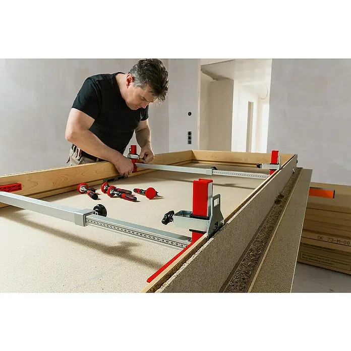 Bessey Türfuttermontagestrebe TU - Spannweite: 565 mm - 1.010 mm - Ein Mann fixiert einen Rahmen mit den BESSEY Korpuszwingen REVO. Die Zwingen spannen die Werkstücke präzise und kraftvoll zusammen.