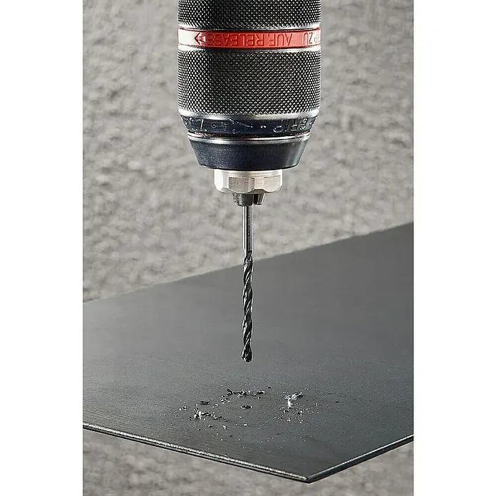 Wolfcraft Metallbohrer rollgewalzt - 1 Stk., Durchmesser Bohrer: 5 mm - Nahaufnahme einer Bohrmaschine, die ein Loch in eine schwarze Metallplatte bohrt und Metallspäne erzeugt.