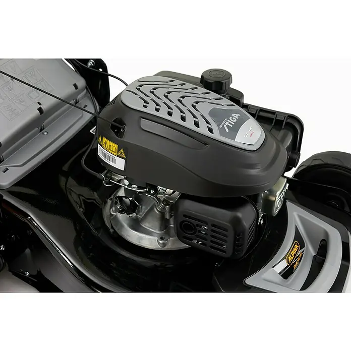 Alpina Cortacésped de gasolina AL546SA - 2,2 kW, 139 cm³, Ancho de corte: 46 cm - Primer plano de un cortacésped Alpina con motor Stiga, modelo ST 140. La máquina es en negro y gris.