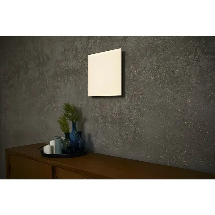 Ledvance Smart+ WiFi LED-Panel Planon Frameless - 40 W, L x B x H: 69 x 596 x 596 mm, Weiß - Eine quadratische LED-Wandleuchte, die helles Licht spendet, hängt über einem Sideboard mit Dekorationen. Das Licht ist ein Blickfang.