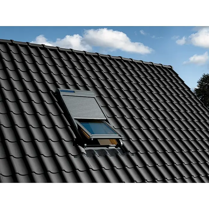 Velux Persiana para ventana de techo Integra Solar SSL CK04 0000S - Adecuado para el tamaño de la ventana: 55 x 98 cm - Primer plano de una claraboya con persianas enrollables en un techo con tejas negras bajo un cielo azul.