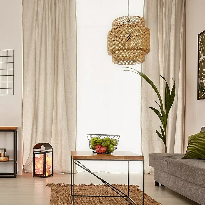 Cortina plisada con fruncido Linum - An x Al: 300 x 300 cm, Lino - Acogedora sala de estar con una pantalla de lámpara decorativa de ratán que cuelga sobre una mesa con un frutero.