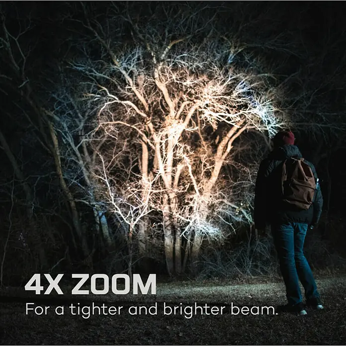 Nebo Tools Linterna Davinci 2000 - 2.000 lm, IP67 - Una persona ilumina un árbol con una lámpara de zoom 4X, destacando un haz más estrecho y brillante.