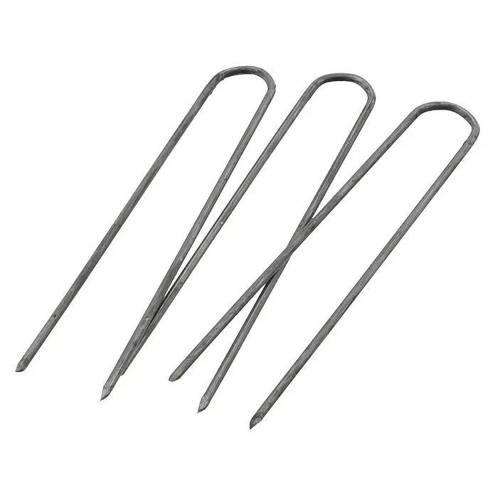 Dekoelement Efeunadeln - Schwarz, Metall, 100 g - Nahaufnahme von drei grauen Zeltheringen, die sich diagonal über einen schwarzen Hintergrund erstrecken und eine robuste Lösung für die Befestigung bieten.