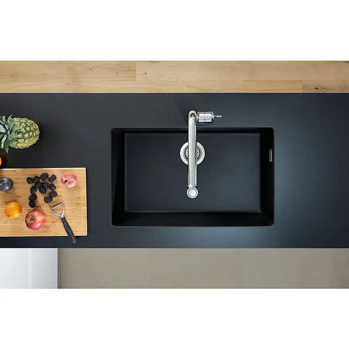 Hansgrohe Fregadero encastrable S510 - U660 1S - 45 x 71 cm, Piedra natural, Grafito, Resplandeciente - Vista cenital de un fregadero de cocina moderno y rectangular en material negro, complementado con un grifo y fruta fresca en la encimera.