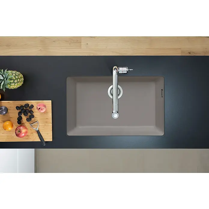 Hansgrohe Fregadero encastrable S510 - U660 1S - 45 x 71 cm, Piedra natural, Cemento, Resplandeciente - Fregadero moderno con grifo integrado en una encimera oscura. Frutas frescas y utensilios de cocina al lado.