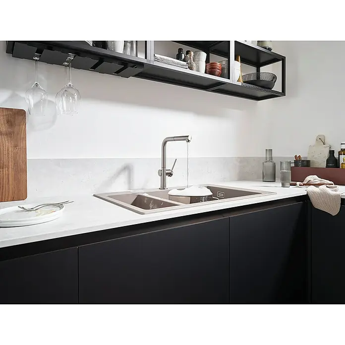 Hansgrohe Grifo de cocina Talis M54 - Cromo, Brillante - Un fregadero de cocina moderno con armarios negros y una encimera gris claro, con copas de vino y platos arriba.