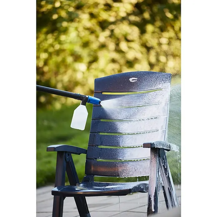 Nilfisk Detergente para plásticos Rattan & Plastic Cleaner - 2,5 l - Una tumbona de plástico se está limpiando con una hidrolavadora y una solución de limpieza.\n