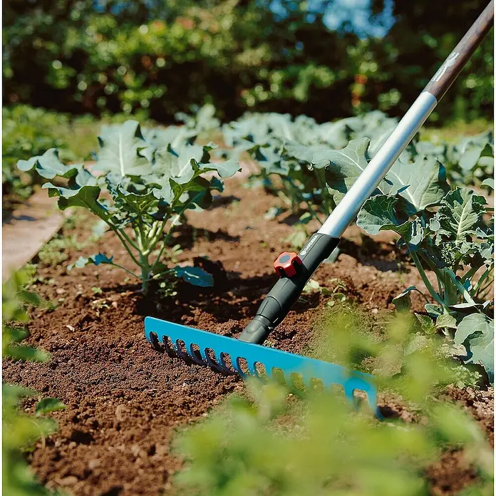 Gardena Combisystem Gartenrechen - Arbeitsbreite: 36 cm, Stahl, Anzahl Zinken: 14 - Nahaufnahme eines blauen Gardena-Rechens im Garten, perfekt zum Einebnen von Beeten und Entfernen von Rückständen.