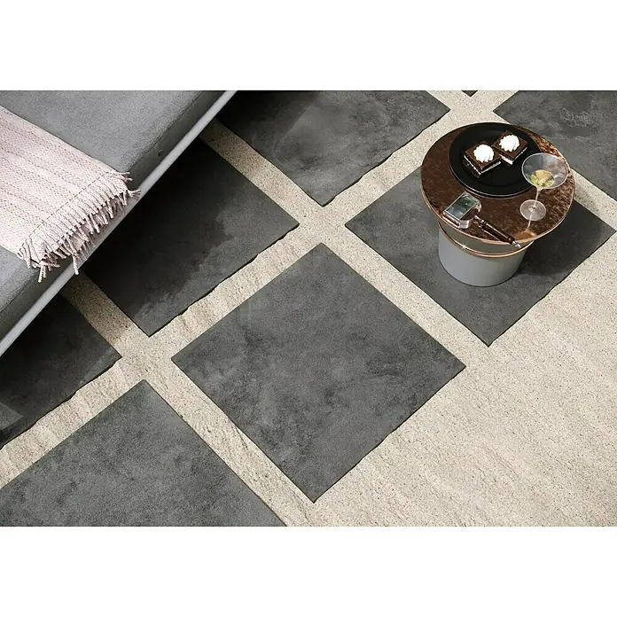 Queens Terrassenfliese - 59,3 x 59,3 x 2 cm, Graphit, Matt - Bild einer grauen Bodenfliese mit sandfarbenen Fugen, die ein modernes und stilvolles Design schafft.\n