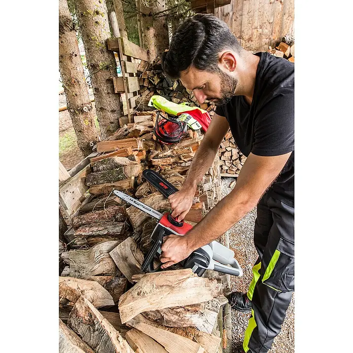 AL-KO 36V Akku-Kettensäge CS 4030 - 36 V, Li-Ionen, Ohne Akku, Schwertlänge: 30 cm - Ein Mann bedient eine AL-KO Akku-Kettensäge vor einem Holzstapel. Ideal für präzise Holzarbeiten im Garten und rund ums Haus.