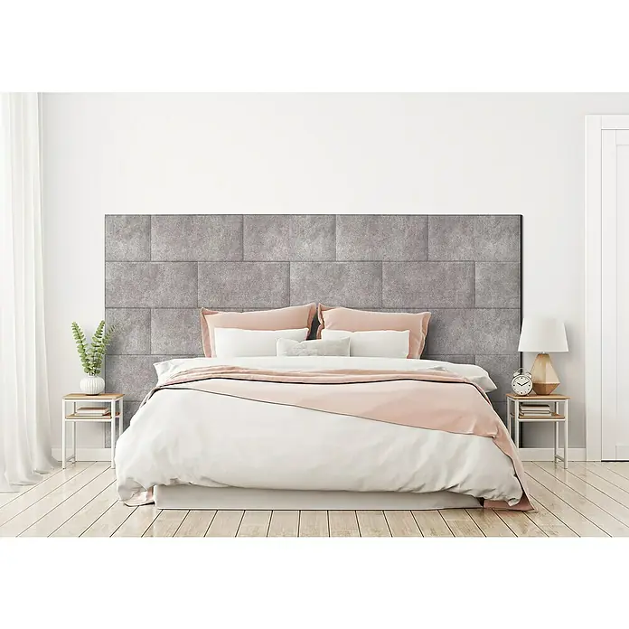 Fllow Wandpolster-Set Velvet A1 - 270 x 150 cm, Beige - Graues modululares Kopfteil über einem Bett mit weißer Bettwäsche und rosa Akzenten, die eine moderne Schlafzimmereinrichtung zeigen.