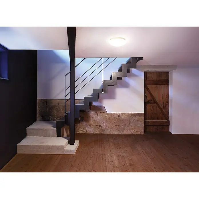 Steinel Sensor-Wand- & Deckenleuchte RS 16 L weiß - 60 W, L x B x H: 27,5 x 27,5 x 9,5 cm, Weiß, E27 - Modernes Treppenhausdesign mit schwebender Treppe, Natursteinwand und Holzboden, beleuchtet durch eine Deckenleuchte, schafft eine einzigartige Atmosphäre.