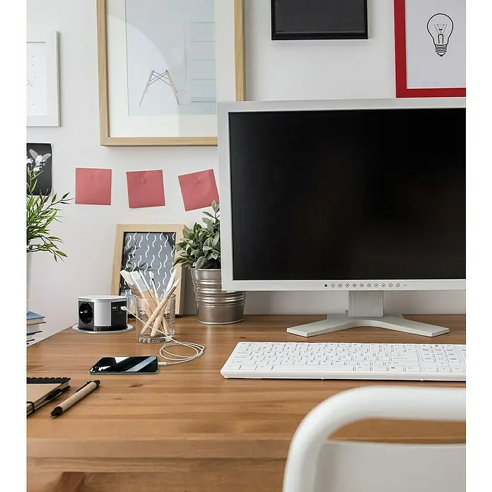 Steckdosensäule - Kunststoff - Schreibtisch-Szene mit Fokus auf den runden, versenkbaren Mehrfachstecker mit USB-Anschlüssen für moderne Geräte.