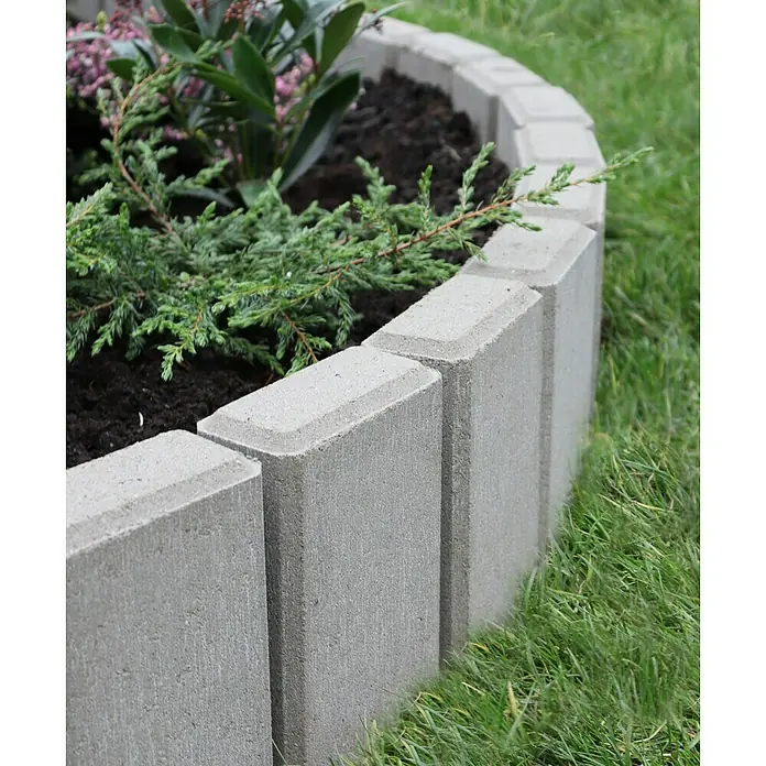 Christoph Palisade C-Line - 12,5 x 6 x 25 cm, Grau, Beton - Diese Aufnahme zeigt eine kreisförmige Beeteinfassung aus grauen Betonsteinen, die einen schönen Übergang zum grünen Rasen bildet.