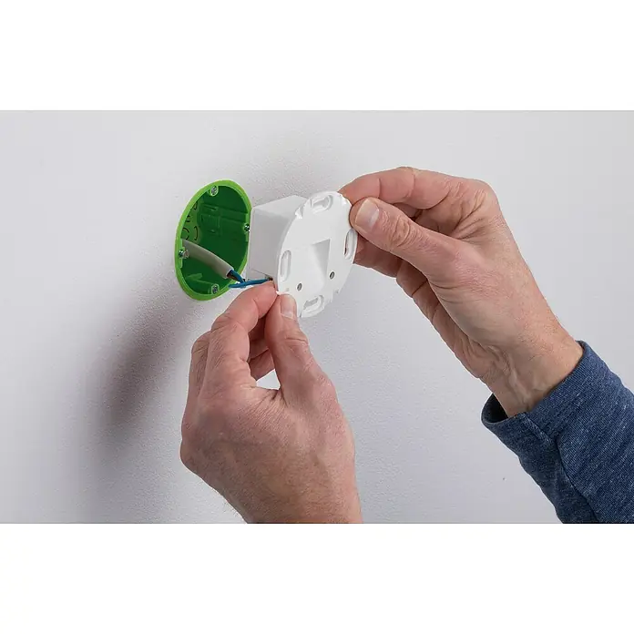 Paulmann LED-Einbauleuchte rund - 2,7 W, Weiß, L x B: 7,8 x 7,8 cm, Rund - Detailaufnahme einer Person, die eine weiße Abdeckung an einer grünen Wanddose mit blauen und weißen Kabeln anbringt.