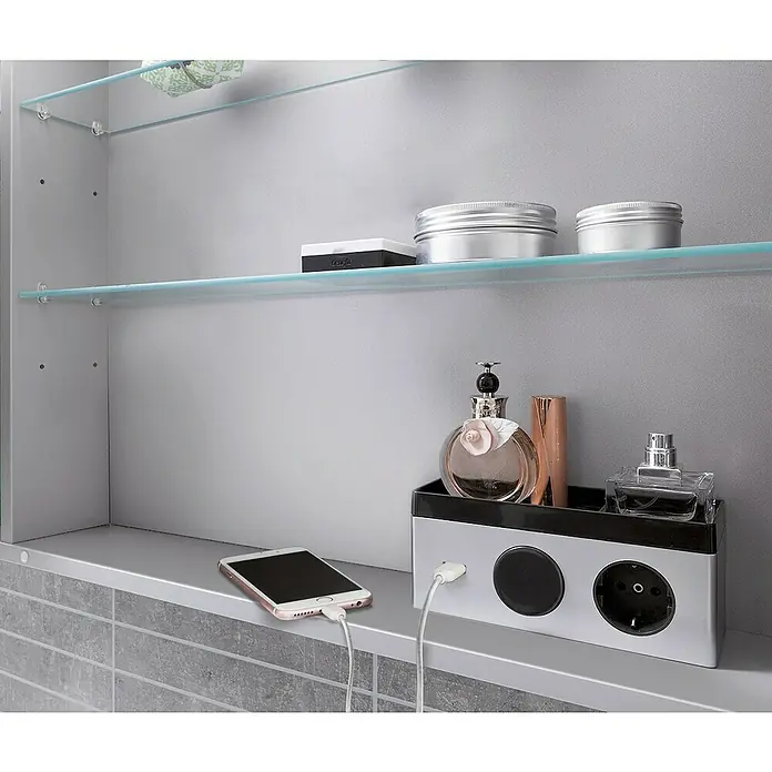 Camargue Stella LED-SpiegelschrankB x H: 120 x 73,7 cm, Holz, Eiche Maron, Mit Beleuchtung, Kantenausführung Tür: Abgerundet - Bild eines Badezimmerspiegelschranks mit Glasablagen, darauf Kosmetika und ein Smartphone, das an einer Steckdose im Schrankinneren geladen wird.